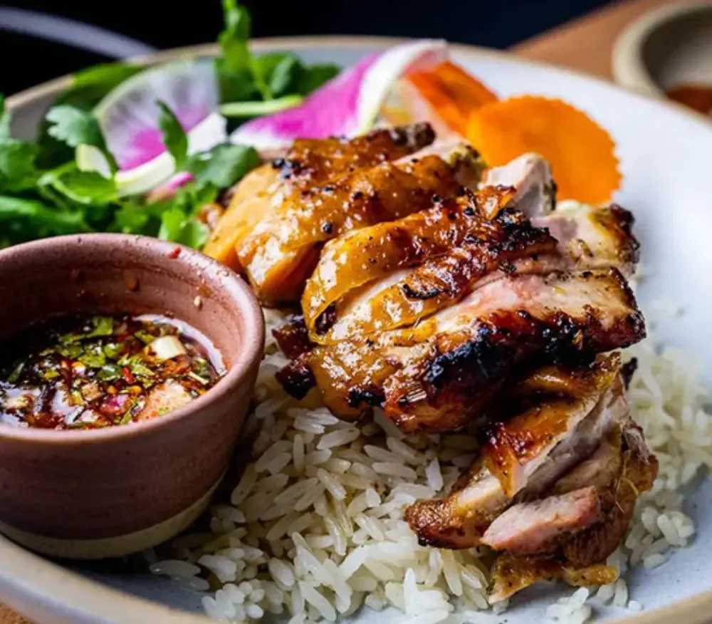 Grilled chicken over rice with fresh herbs and dipping sauce